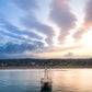 Hermosa Beach Pier extending into the ocean with a cityscape and colorful sky in the background.