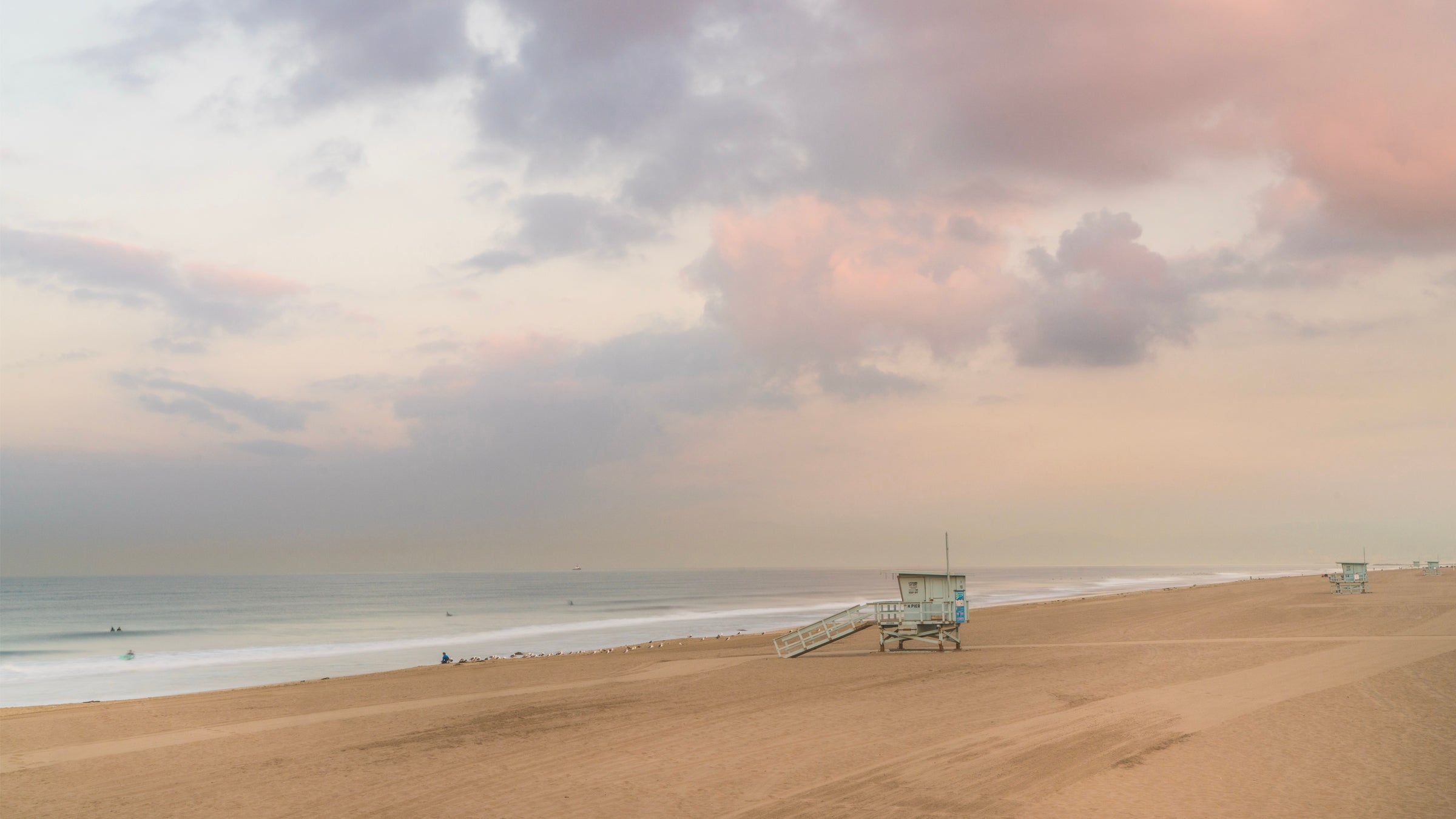 Beach scene with a lifeguard tower under a cloudy sky